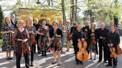 Collegium Musicum jousiorkesteri ulkona auringonpaisteessa.