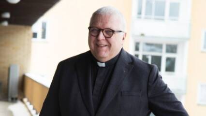 Kirkkoherra Juhani Korte seisoo luhtitalon parvekkeella.