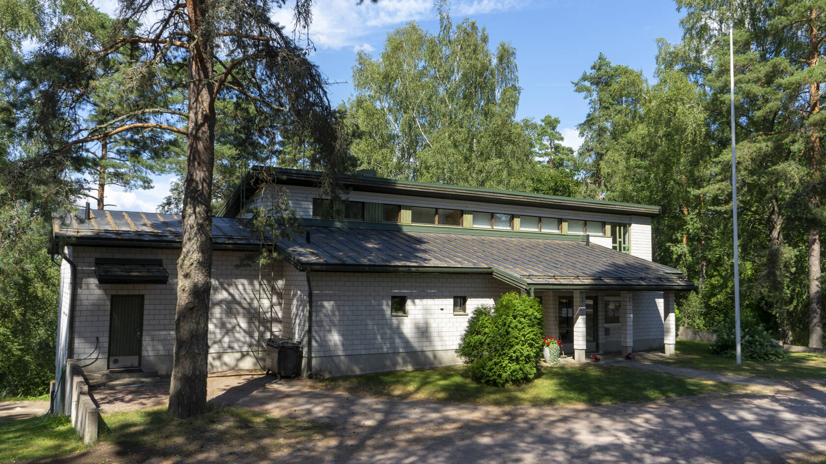 En vit byggnad bland träd.