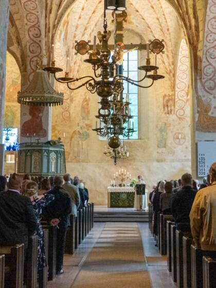 Människor står i gudstjänsten i S:t Lars kyrka.