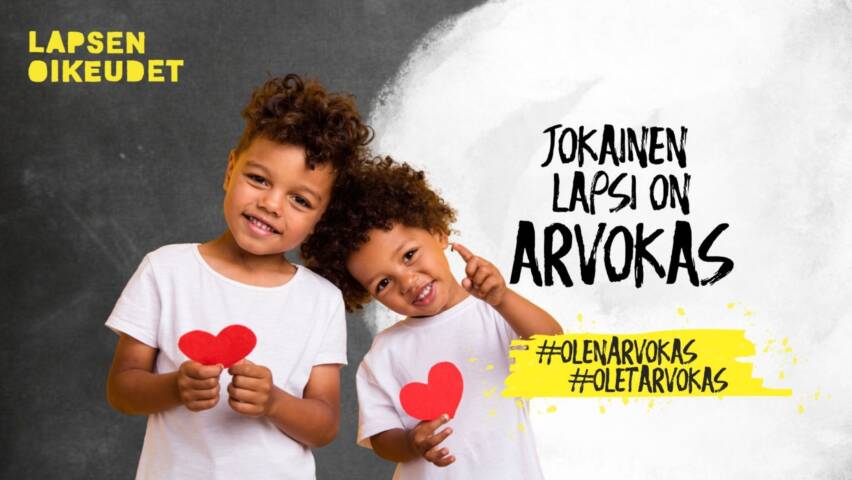 Kaksi lasta paperisten sydänten kanssa. Teksti: Jokainen lapsi on arvokas.